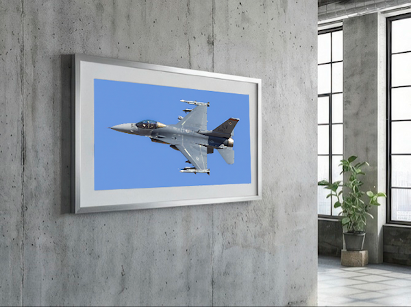 Large framed F-16 Fighting Falcon photography print titled "Viper Launch: Red Flag 25-1" hanging on a modern industrial concrete wall. The panoramic aviation art by PES Editions features a U.S. Air Force jet against a blue sky.