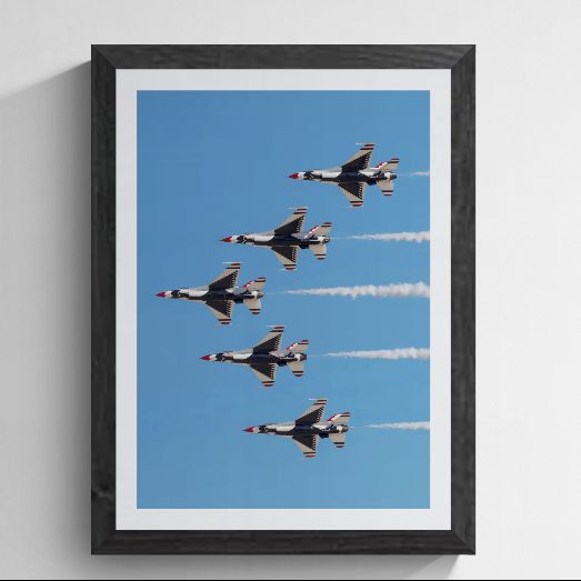 Limited edition U.S. Air Force Thunderbird F-16 photography print titled "Delta Prime" by Phil Schmauder at Nellis AFB. This vertical master captures five jets in a tight delta formation with crisp smoke trails, professionally presented in a textured black gallery frame with a wide white mat on a light grey background.
