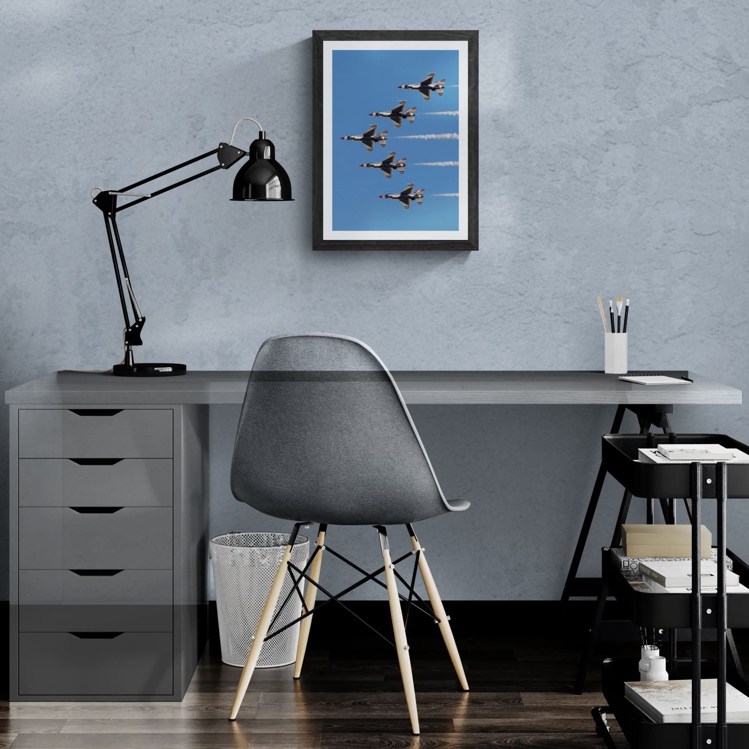 A 14x20 "Standard Edition" of the vertical "Delta Prime" Thunderbird print featured in a modern home office. The textured black gallery frame is mounted on a light-blue textured wall above a white desk, demonstrating the print’s vertical scale and synchronized detail in a personal gallery setting.