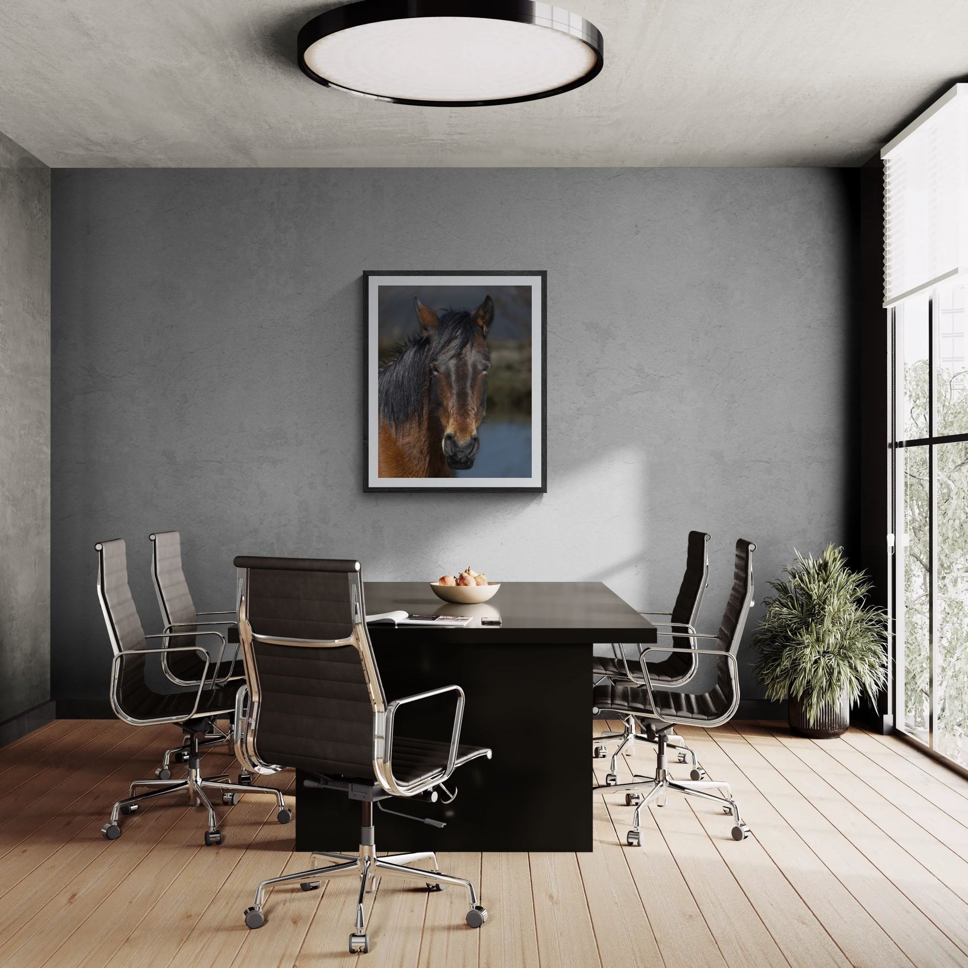 A large-format 32x40 "Statement Edition" of the "Resilient Spirit" Wild Mustang print commanding a professional boardroom. The wildlife artwork is displayed in a textured black frame on a grey concrete feature wall, highlighting its high-fidelity detail and presence in a luxury interior space.