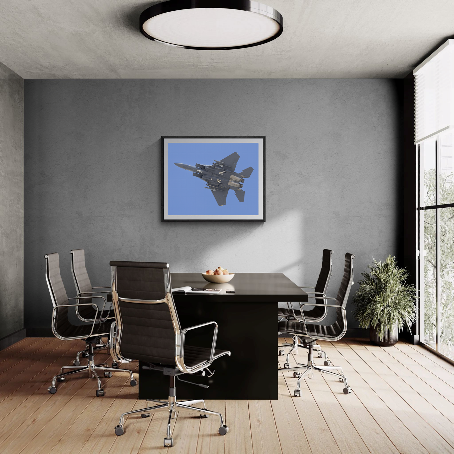 Large framed F-15 Strike Eagle aviation art print hanging on a grey feature wall in a sleek, modern conference room.