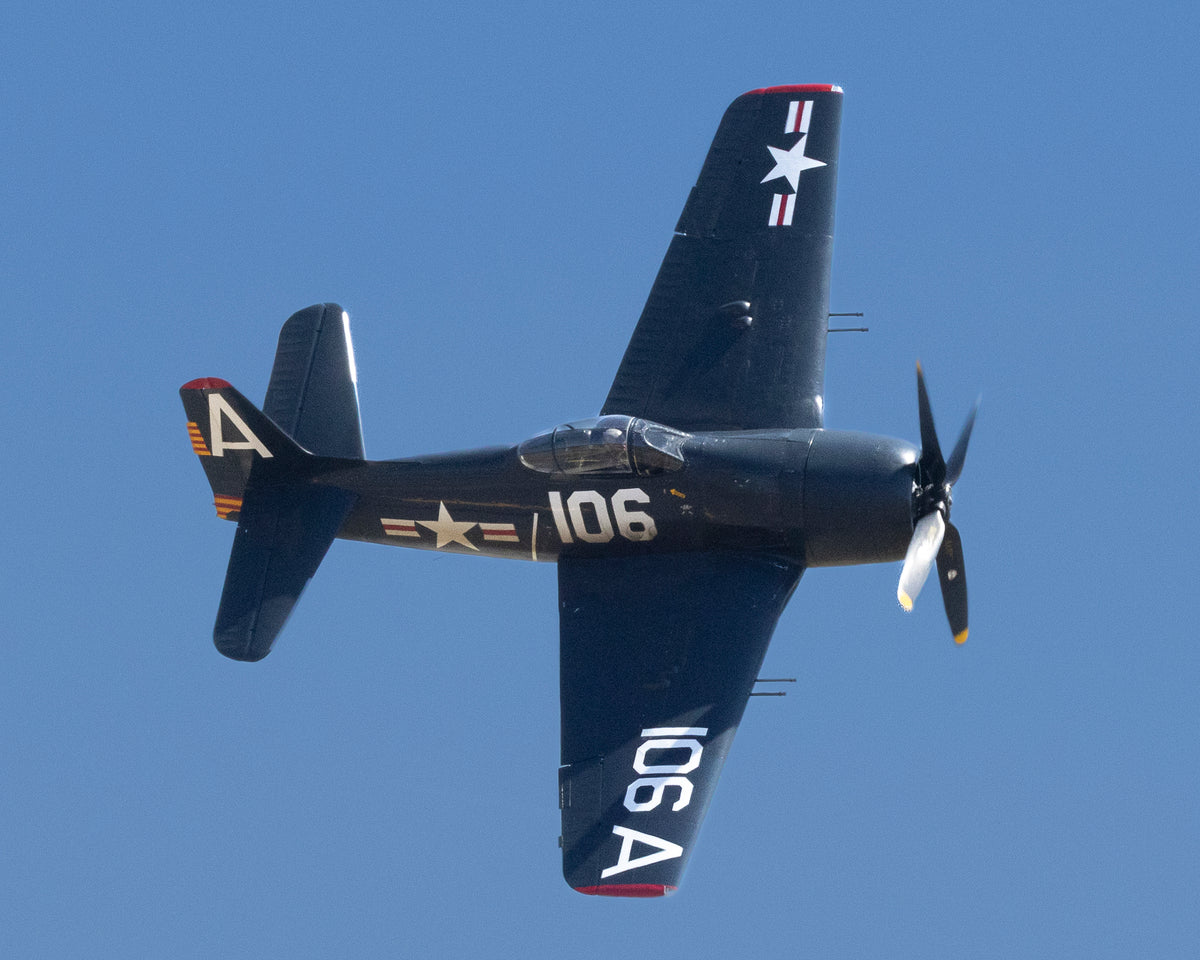 Grumman F8F Bearcat carrier interceptor in a steep vertical diving turn against blue sky, fine art warbird print by Phil Schmauder.