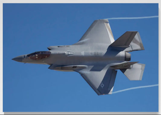 F-35A Lightning II banking topside with visible wing vortexes in a blue sky, limited edition HD aluminum metal print with recessed float mount by Phil Schmauder.